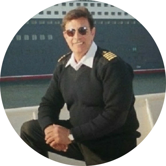 A man in uniform sitting on the dock of a boat.